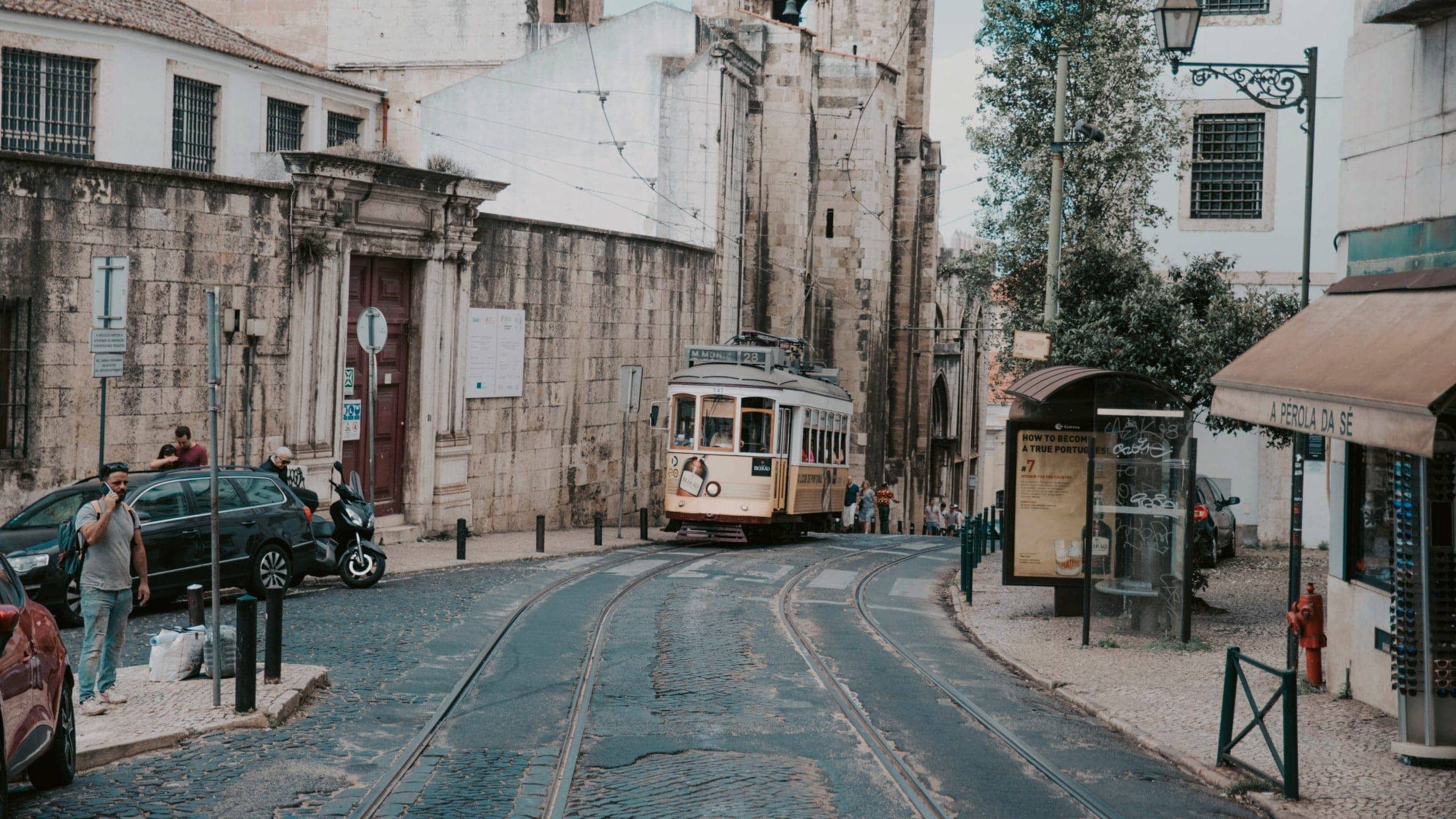 Lisbon's iconic yellow tram winds through the city's historic streets on the Contiki Best of Spain, Portugal & Morocco Tour