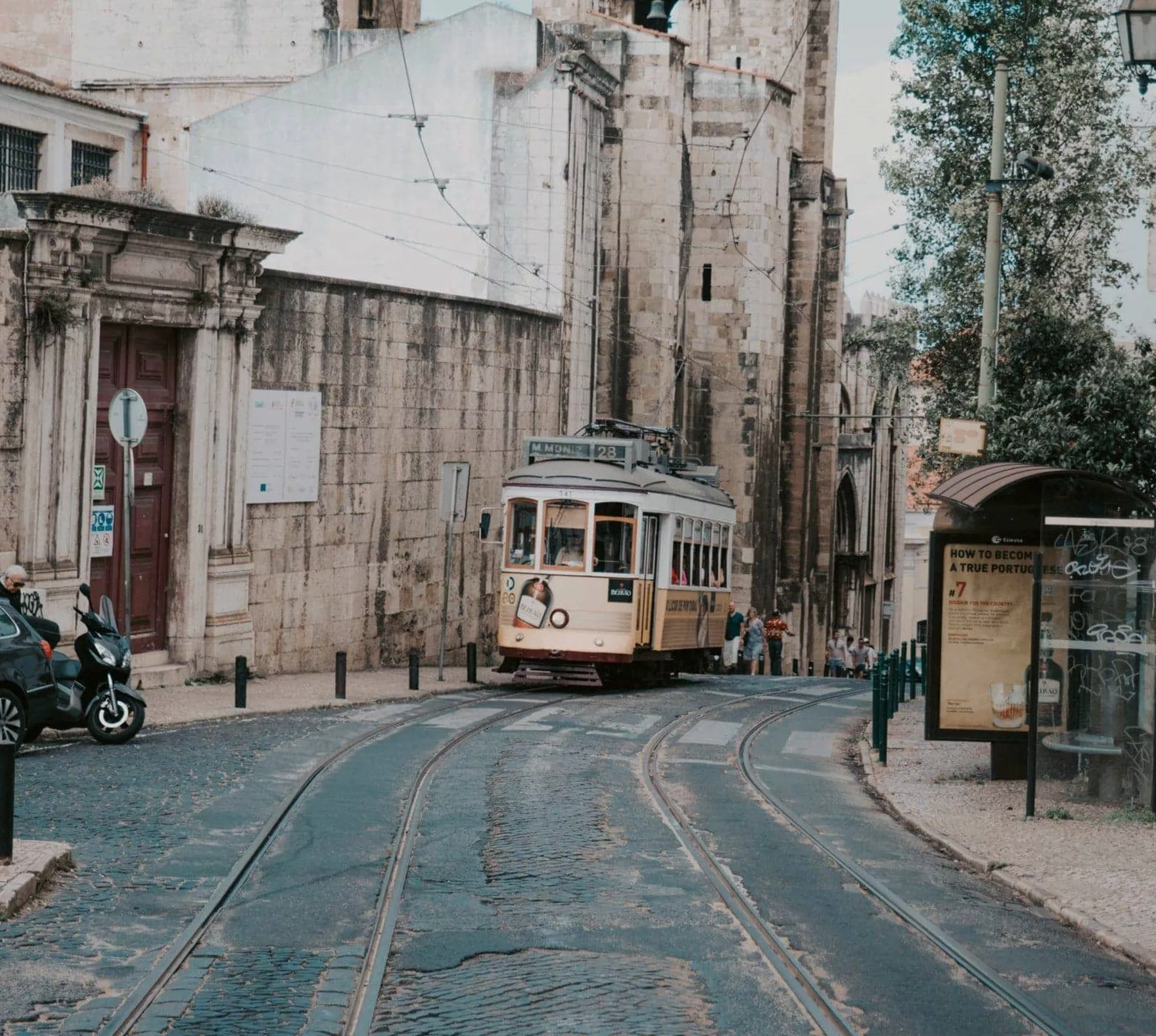 Lisbon's iconic yellow tram winds through the city's historic streets on the Contiki Best of Spain, Portugal & Morocco Tour