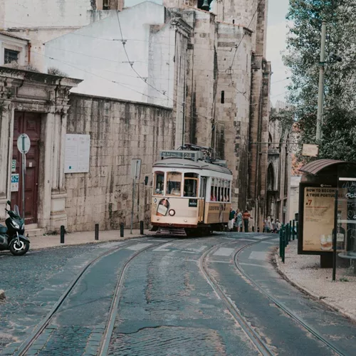 Lisbon's iconic yellow tram winds through the city's historic streets on the Contiki Best of Spain, Portugal & Morocco Tour