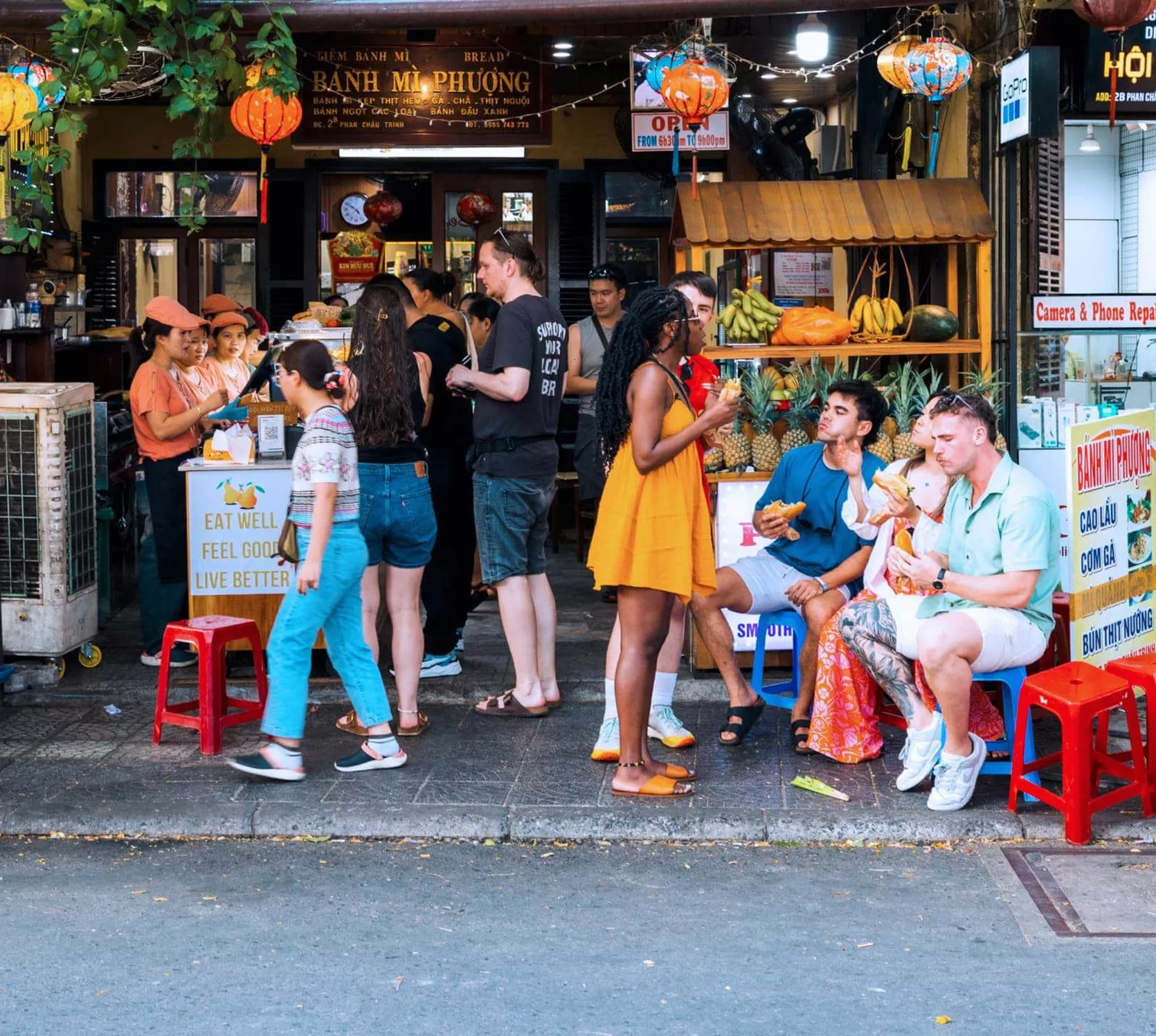 Travellers eating bánh mì outside the famous Bánh Mì Phượng shop in Hội An Vietnam - Contiki Vietnam Tour