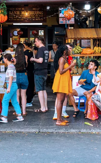 Travellers eating bánh mì outside the famous Bánh Mì Phượng shop in Hội An Vietnam - Contiki Vietnam Tour