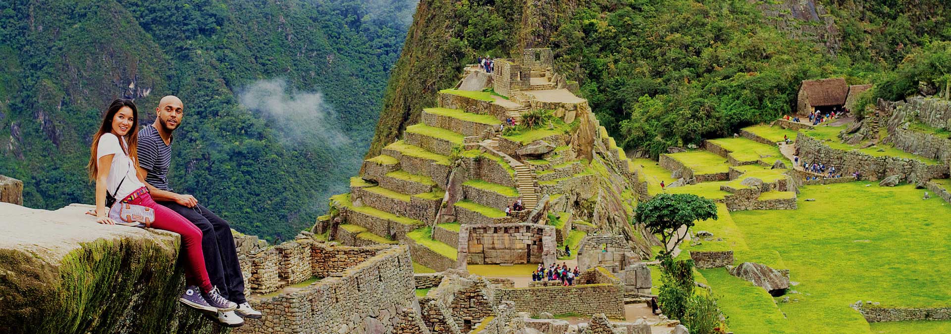 Copuple sitting on a Rock with view on Machu Picchu in Peru