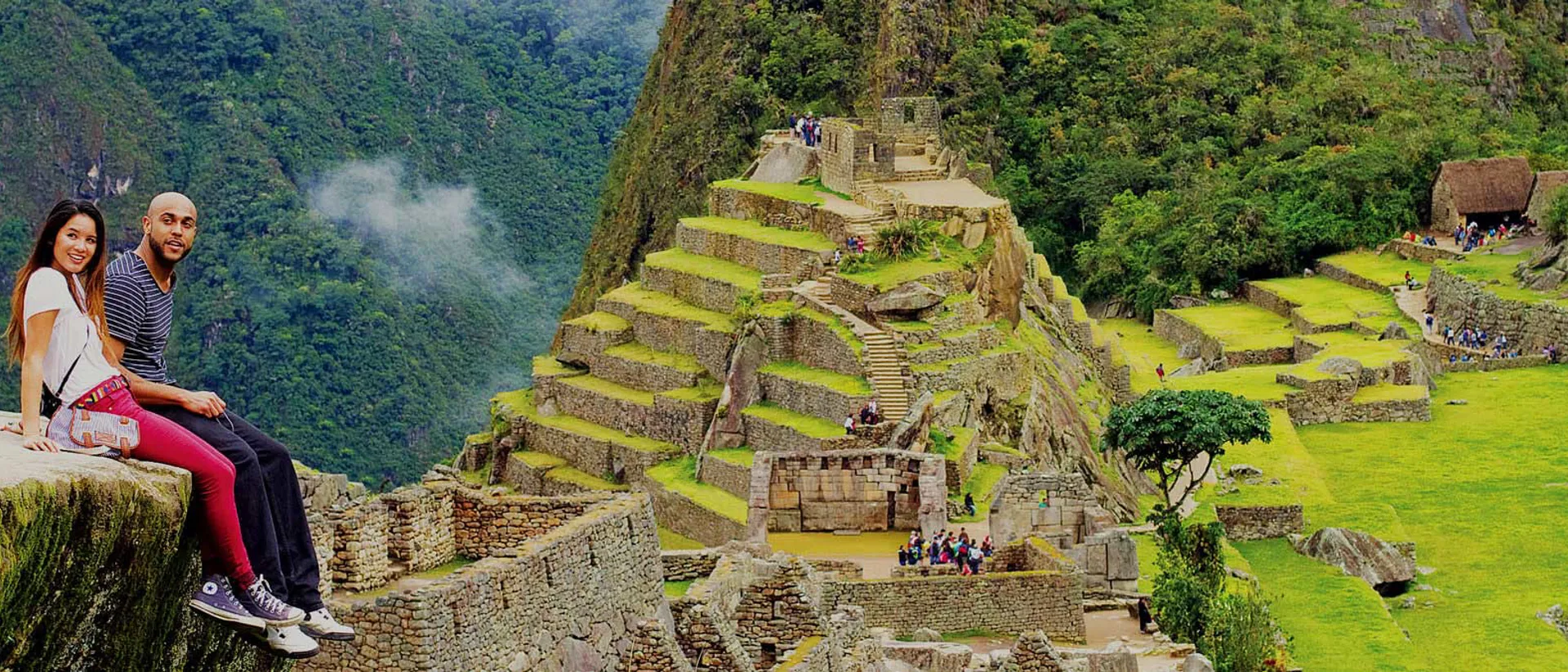 Copuple sitting on a Rock with view on Machu Picchu in Peru