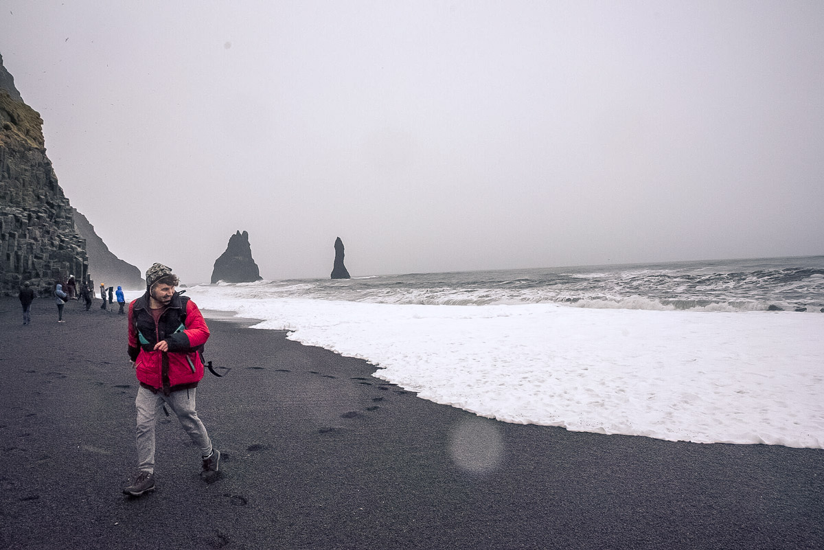 Man Walking On A Black Sand Beach