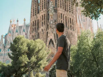 Barcelona's spectacular Sagrada Família towers above a traveller exploring the city on the Contiki Best of Spain Tour
