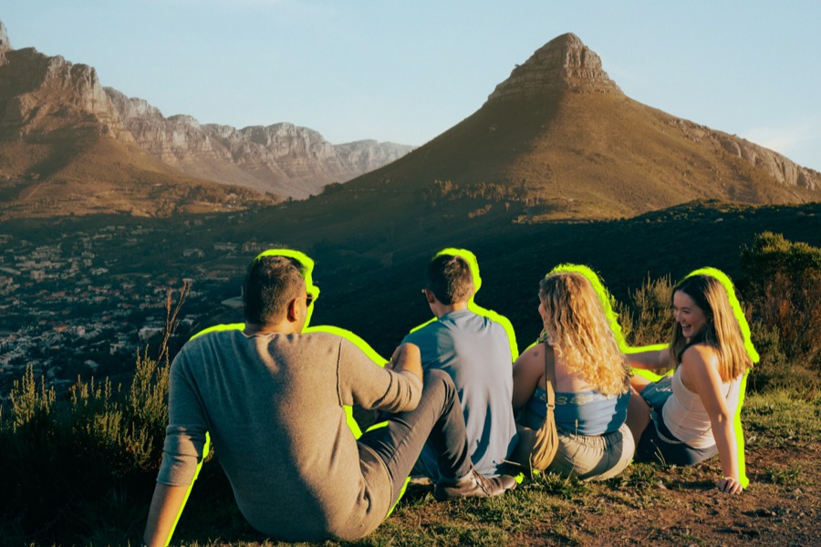 A group of friends are sitting at hilltop.