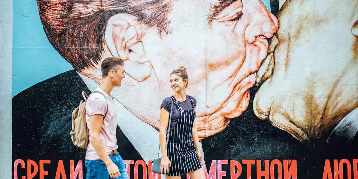 Travellers walking past the Berlin Wall in Germany