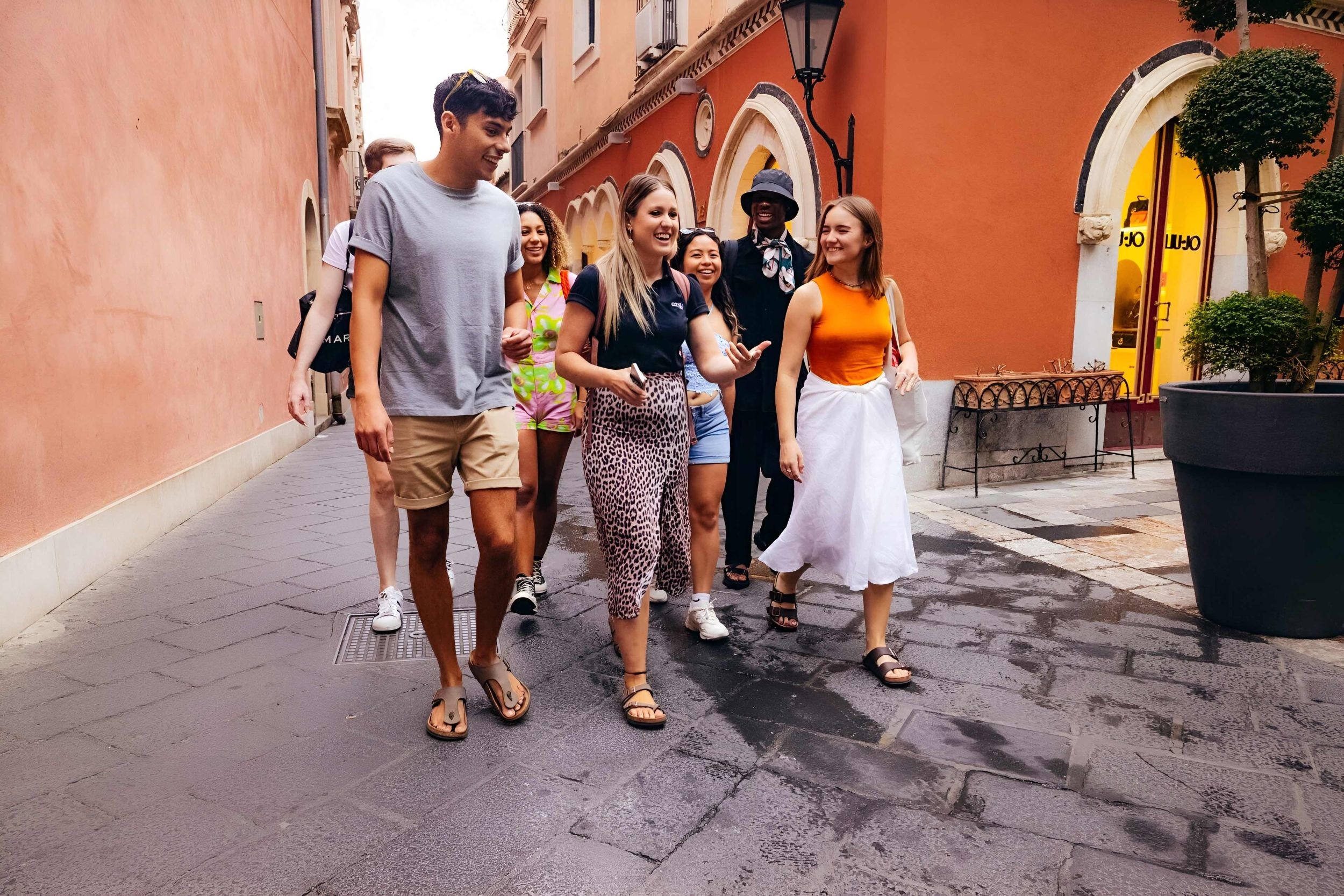 Happy tourists walking down a street in old part of city