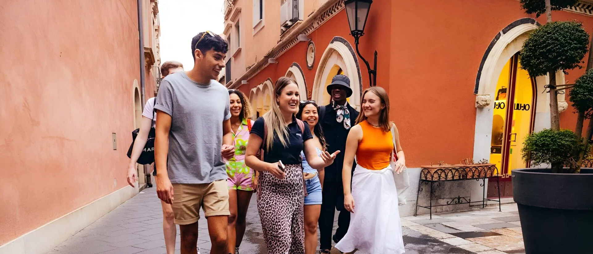 Happy tourists walking down a street in old part of city