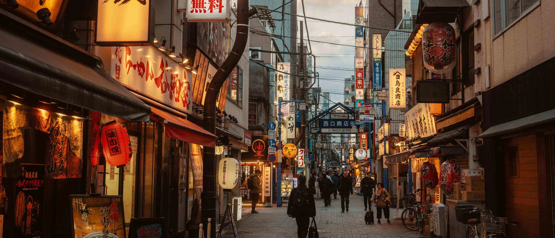A Narrow Lantern Lit Street Lined With Signage And Ramen Shops In Tokyo, Japan