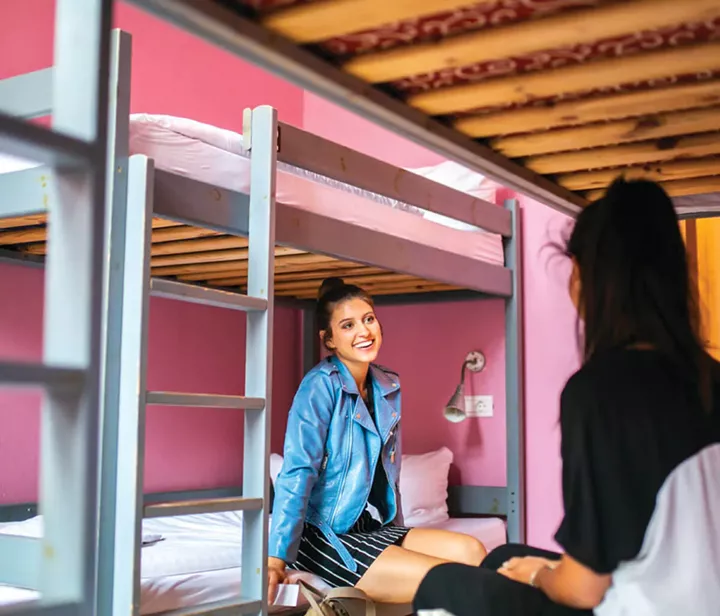 Girls sit on bunk beds and talk