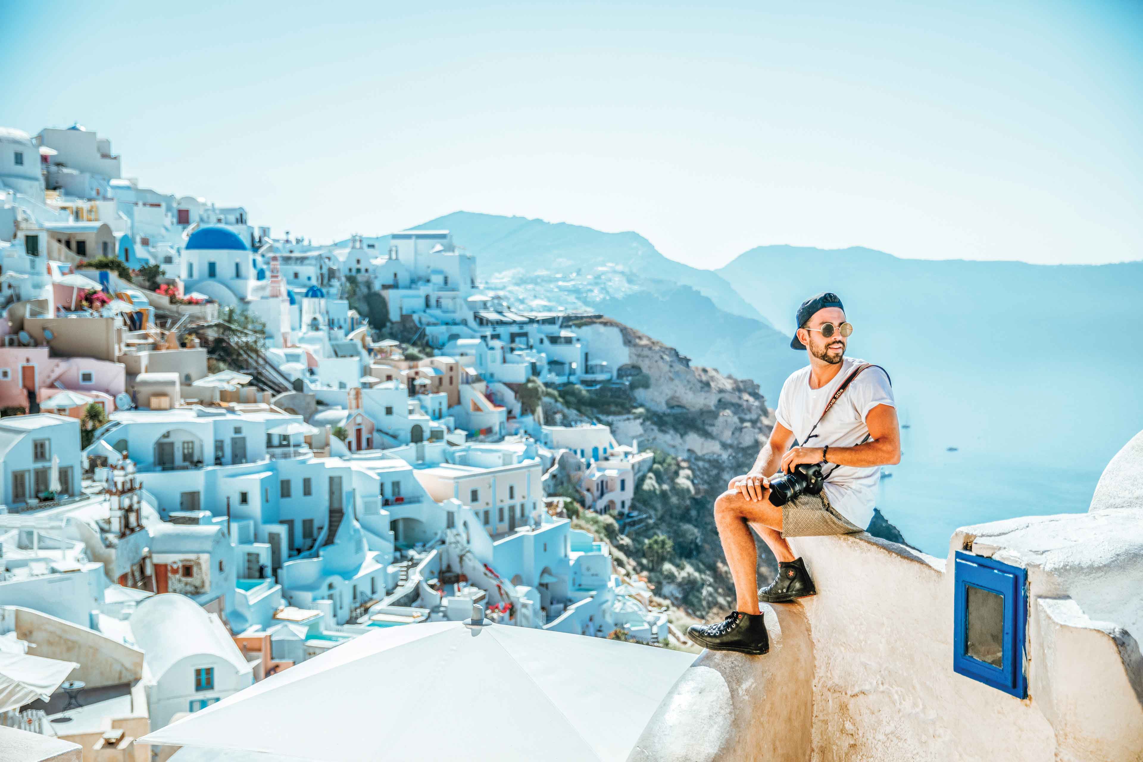 Man On Greek Rooftops With Camera In Santorini