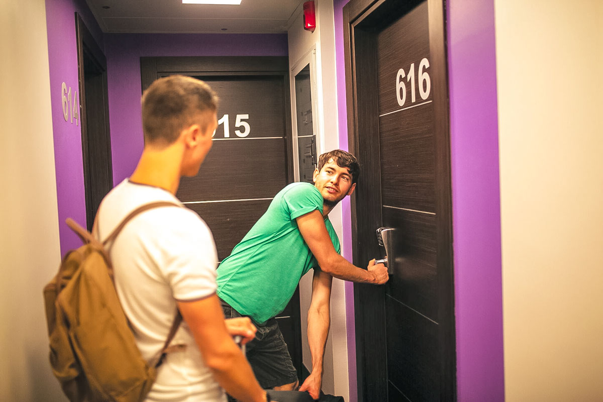 Two Friends Openning Door To Enter Their Accommodation