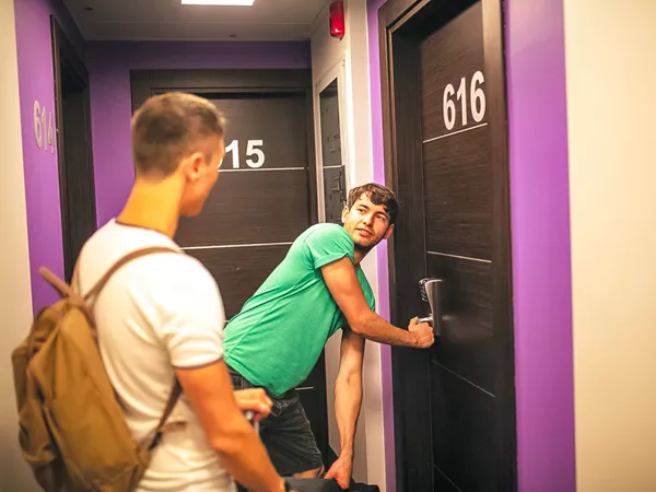 Two Friends Openning Door To Enter Their Accommodation