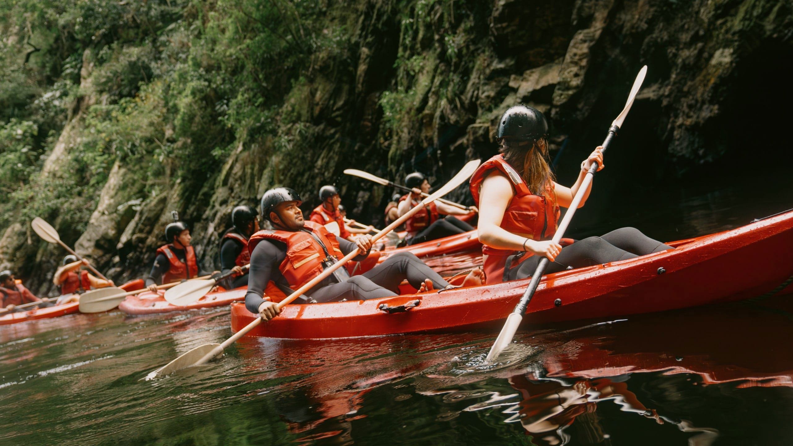Travellers kayaking through the river on Contiki's Garden Route & Addo Tour in South Africa