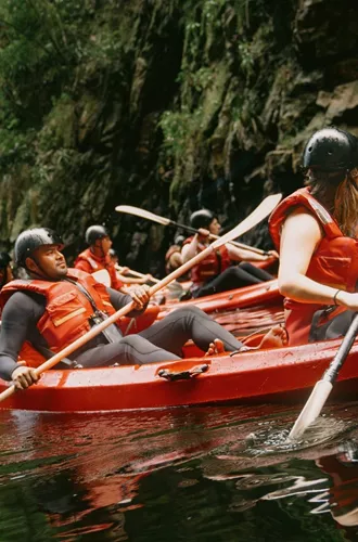Travellers kayaking through the river on Contiki's Garden Route & Addo Tour in South Africa