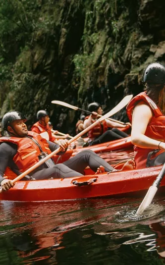 Travellers kayaking through the river on Contiki's Garden Route & Addo Tour in South Africa