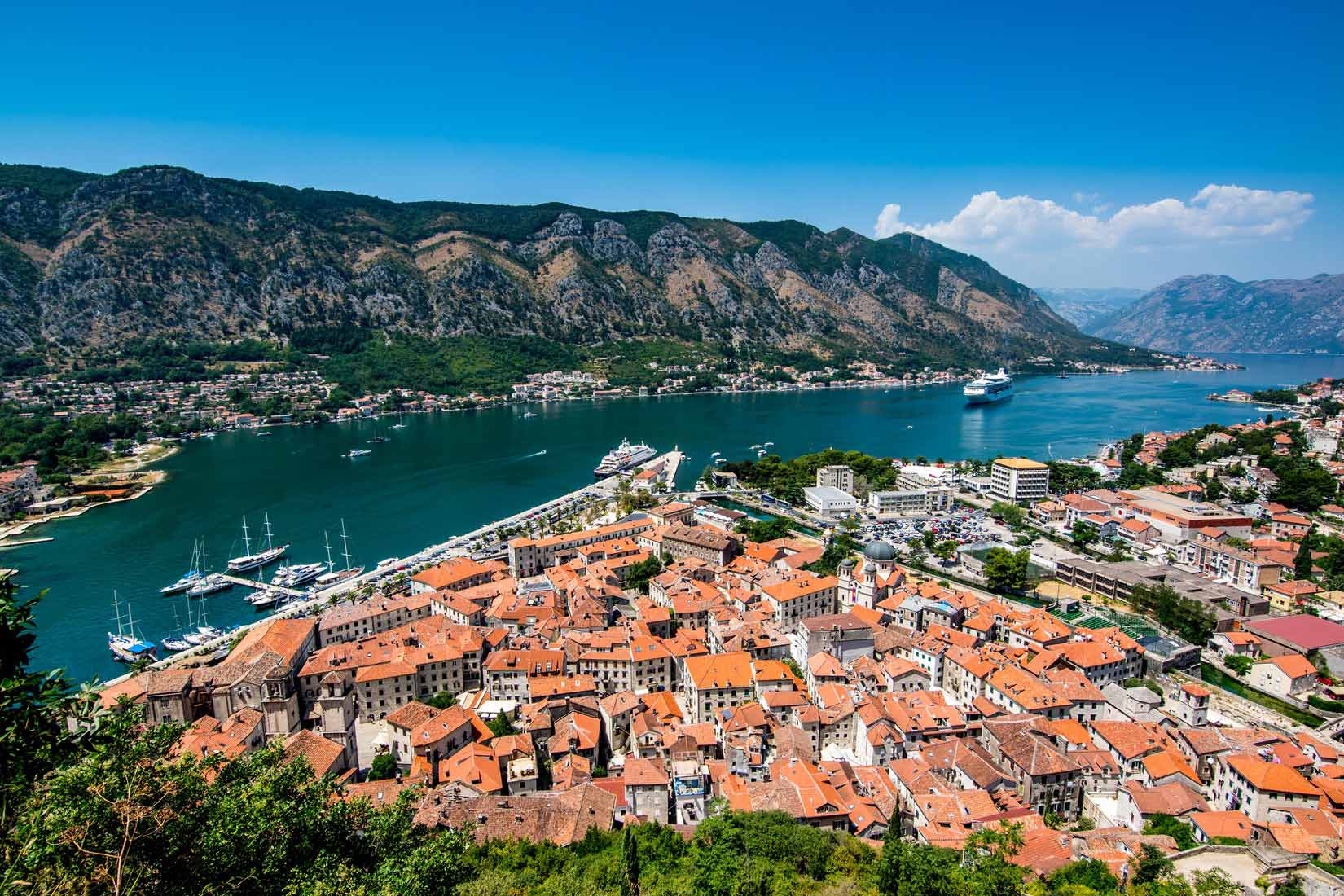 Red roof of Kotor city buildings located by the shore in Montenegro
