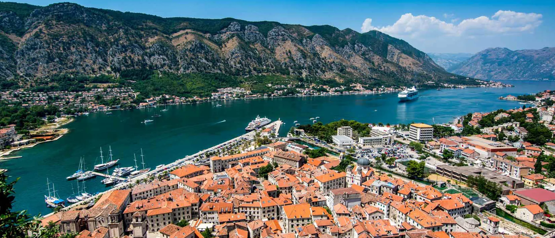 Red roof of Kotor city buildings located by the shore in Montenegro