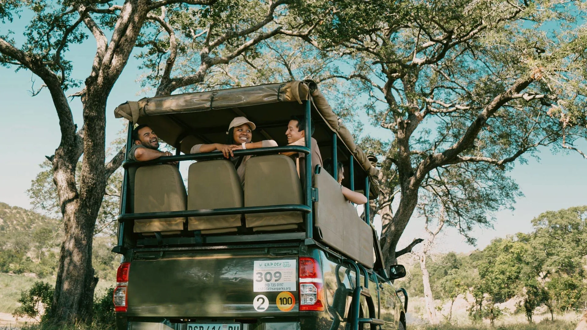 Travellers riding in an open safari vehicle during a game drive - Contiki South Africa & Botswana Safari Tour