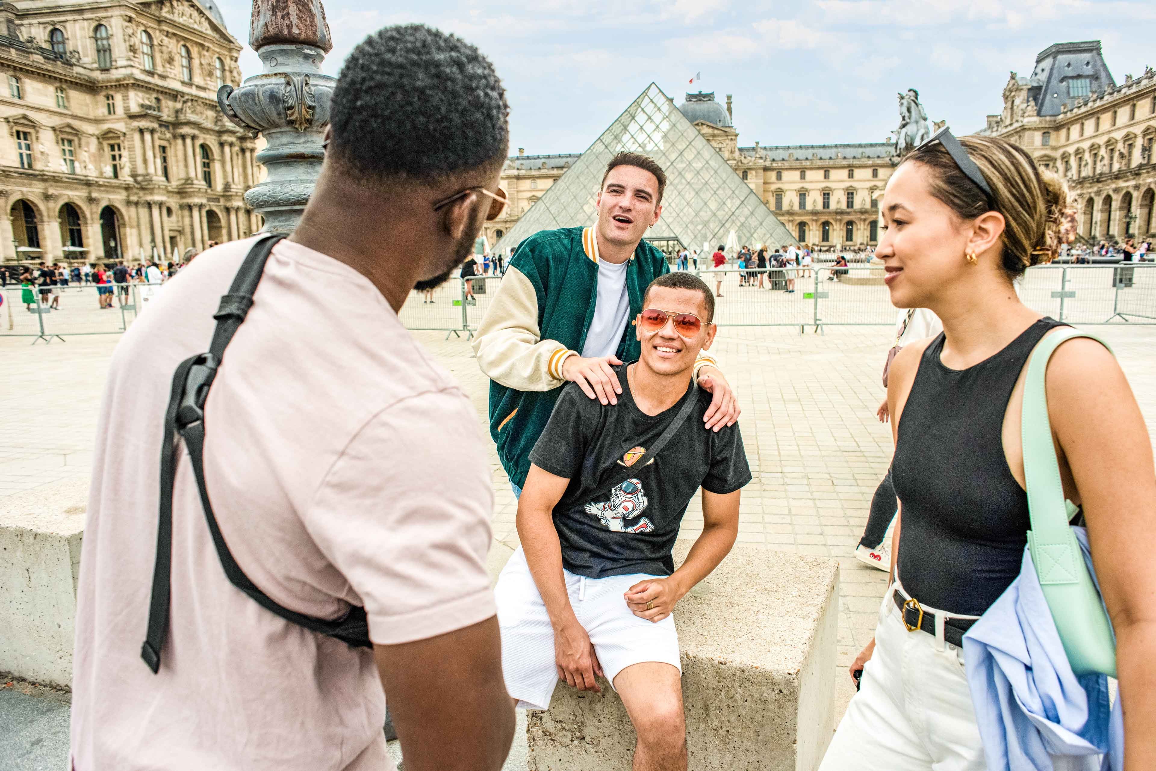 Group in font o Louvre glass pyramid in Paris, France
