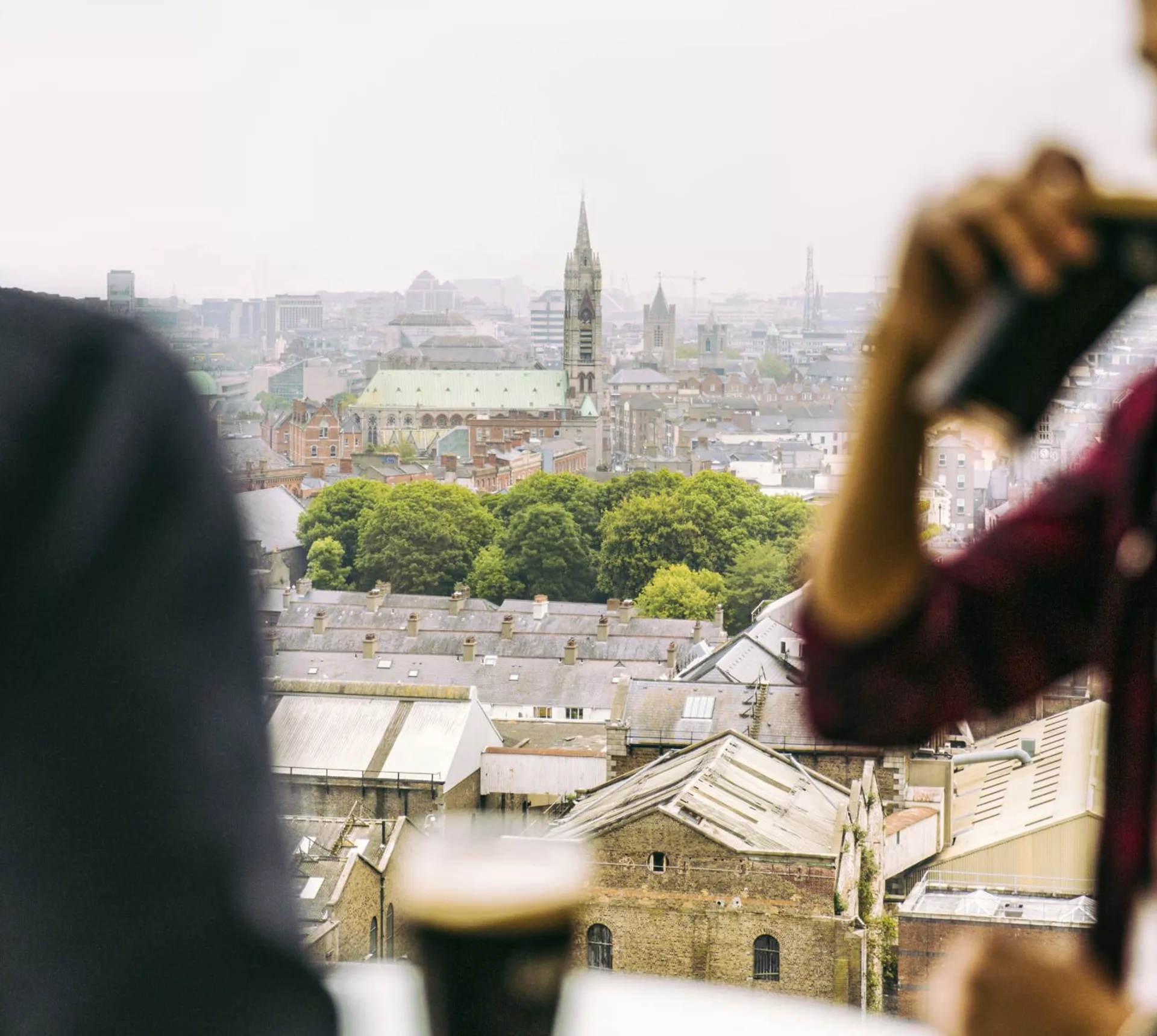 Traveller drinking a pint of Guinness at the Guinness Storehouse rooftop bar overlooking the Dublin city skyline - Contiki St Patrick's Day Festival Tour Ireland