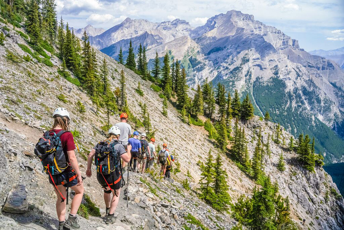 A group of people hiking a snowy mountain as a background in Canada.