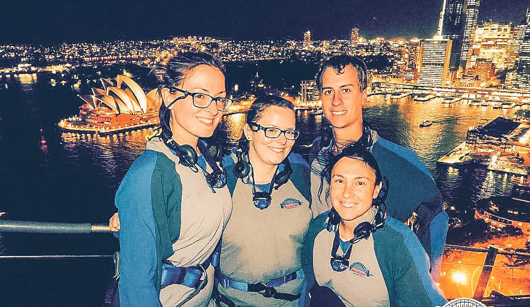 Young people posing for a photo with Sydney city skyline