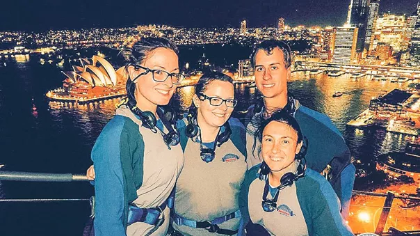 Young people posing for a photo with Sydney city skyline