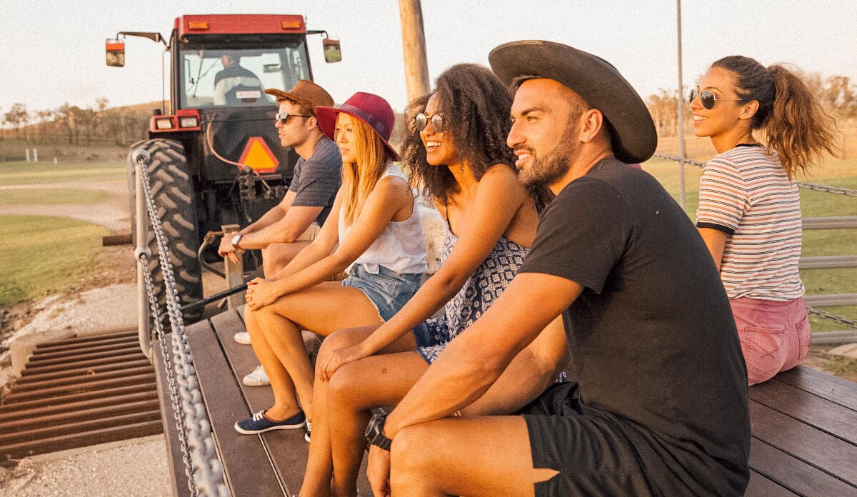 Young smiling people sitting on a tractor trailer