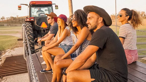 Young smiling people sitting on a tractor trailer
