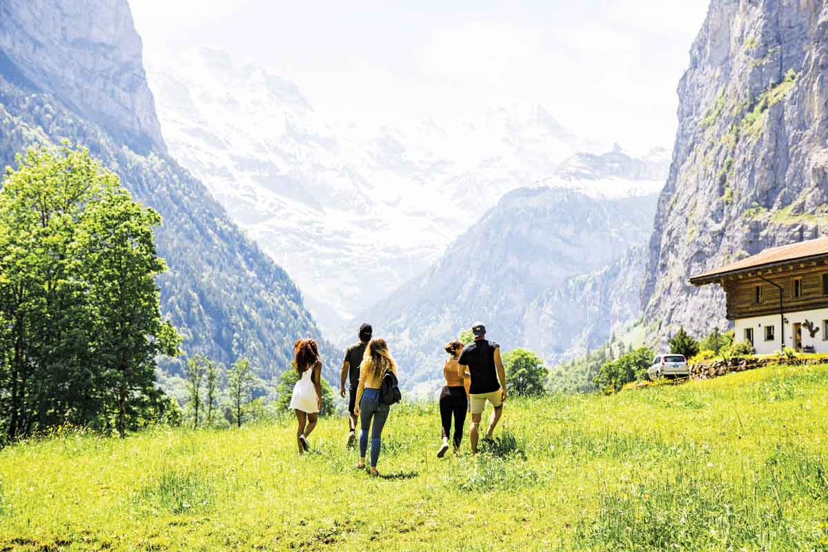 Travellers Walking Ina Field In The Alps