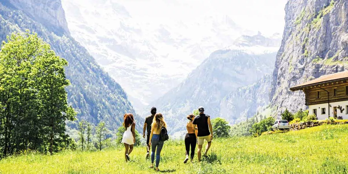 Travellers Walking Ina Field In The Alps