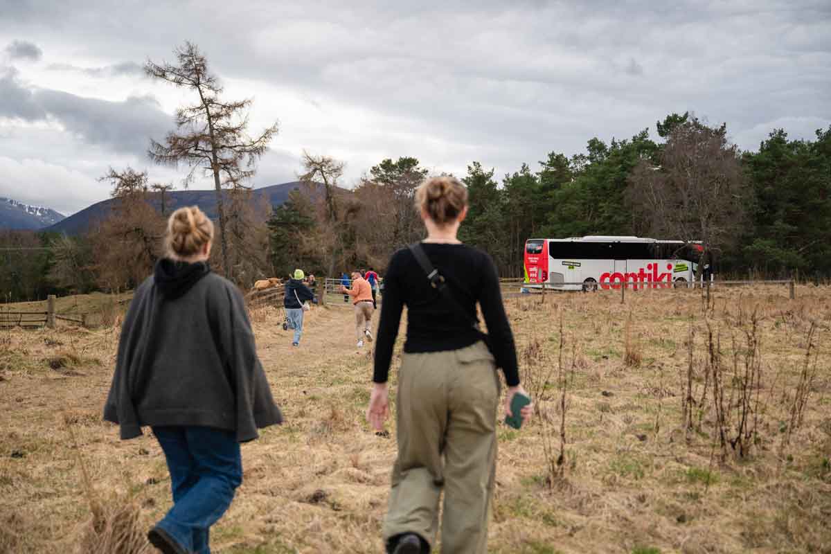 Women going to the Contiki bus in the countryside in Scotland