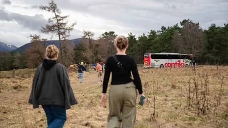 Women going to the Contiki bus in the countryside in Scotland