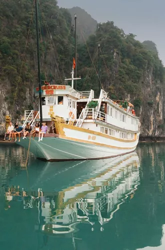 Contiki travellers relaxing aboard an overnight cruise through Ha Long Bay, Vietnam, surrounded by towering limestone karsts on the Ultimate South East Asia Tour