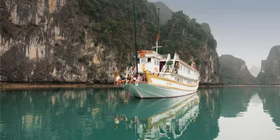 Contiki travellers relaxing aboard an overnight cruise through Ha Long Bay, Vietnam, surrounded by towering limestone karsts on the Ultimate South East Asia Tour