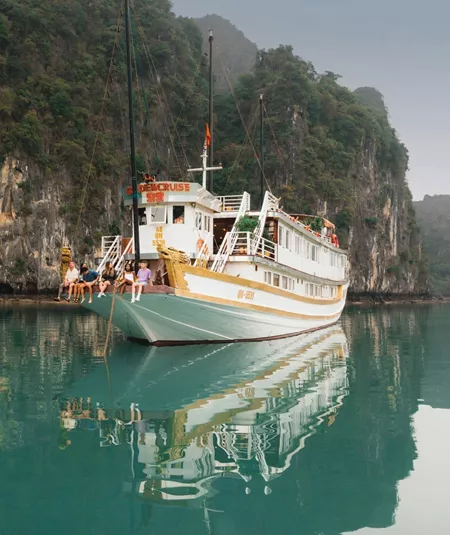 Contiki travellers relaxing aboard an overnight cruise through Ha Long Bay, Vietnam, surrounded by towering limestone karsts on the Ultimate South East Asia Tour