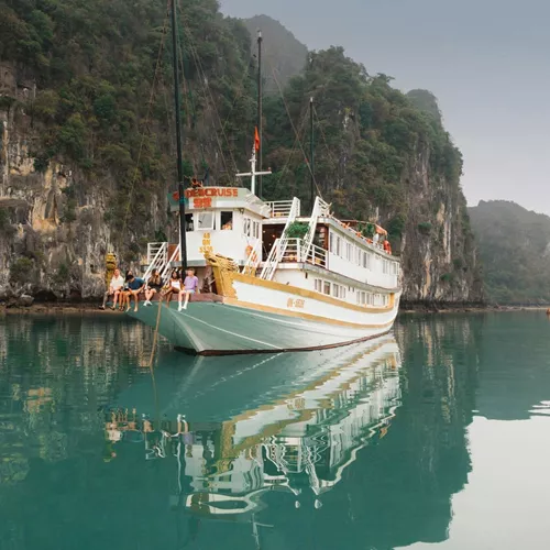 Contiki travellers relaxing aboard an overnight cruise through Ha Long Bay, Vietnam, surrounded by towering limestone karsts on the Ultimate South East Asia Tour
