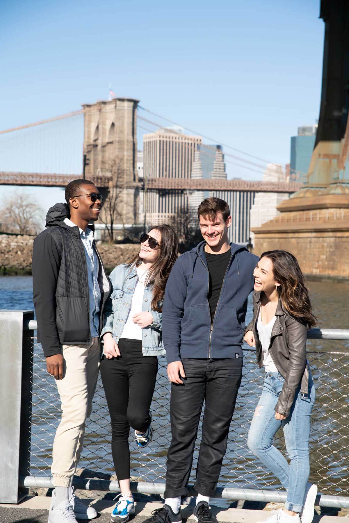 Group In The Winter Sun In Front Of Brooklyn Bridge New York