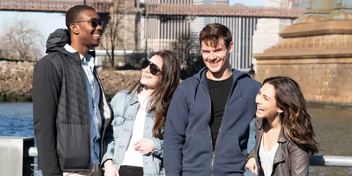 Group In The Winter Sun In Front Of Brooklyn Bridge New York