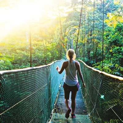 A woman on a rope walking on a bridge