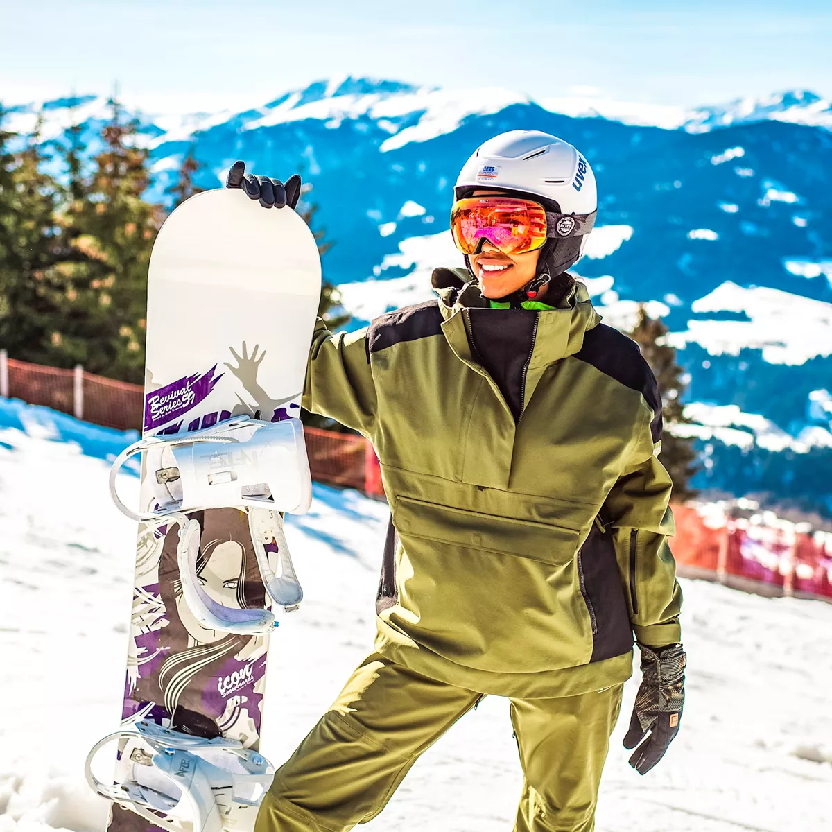 person with snowboard green snowsuit mountain sunshine