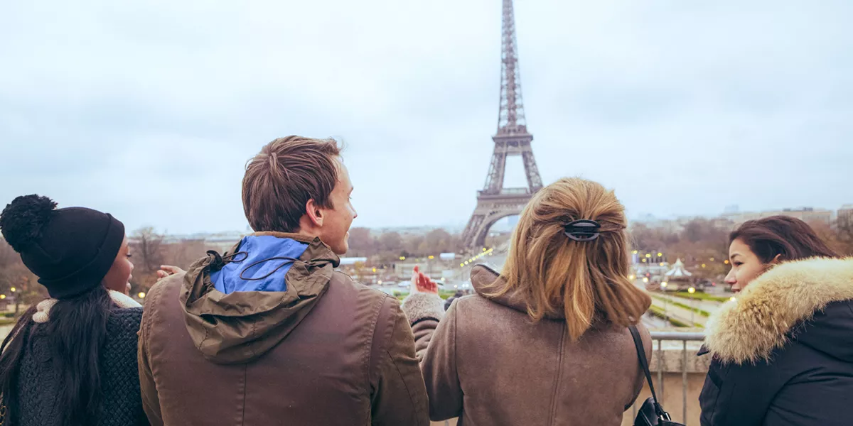Travellers pose for a selfie in front of the Eiffel Tower, in Paris, France