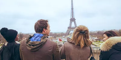 Travellers pose for a selfie in front of the Eiffel Tower, in Paris, France