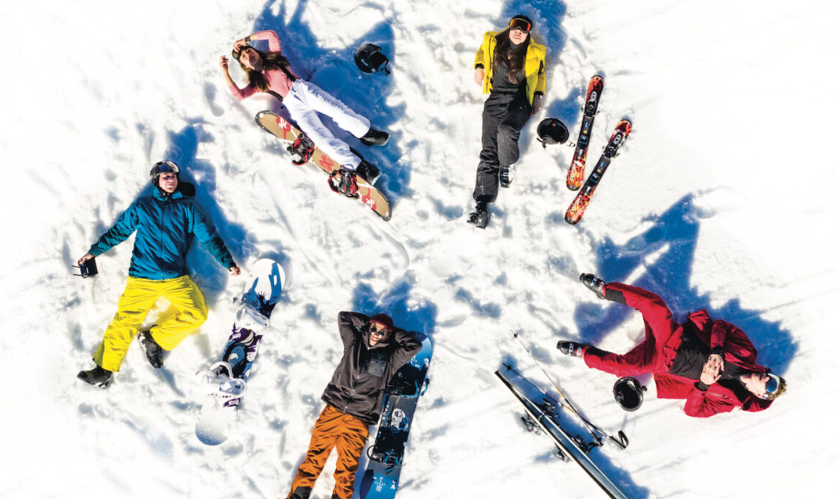 Group Of Young People Lying In Snow