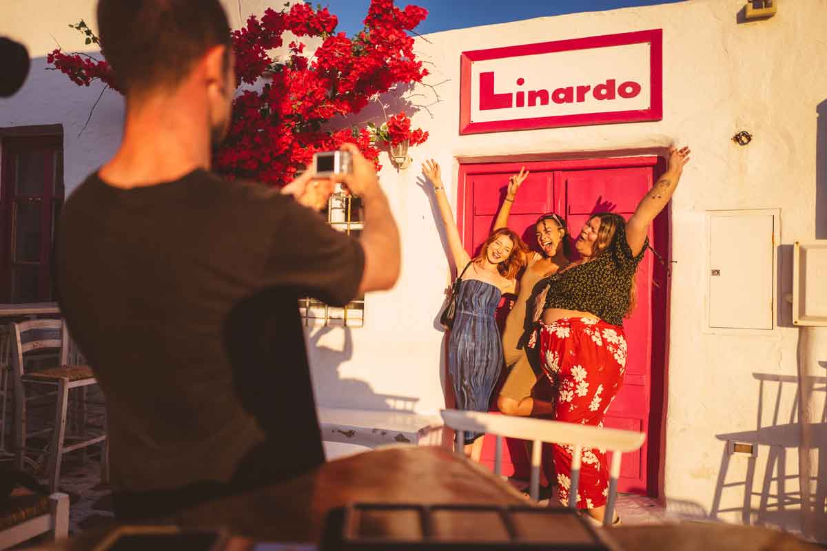 Traveller taking a photo of group outside Linardo, Paros, Greece