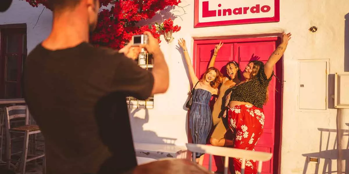 Traveller taking a photo of group outside Linardo, Paros, Greece