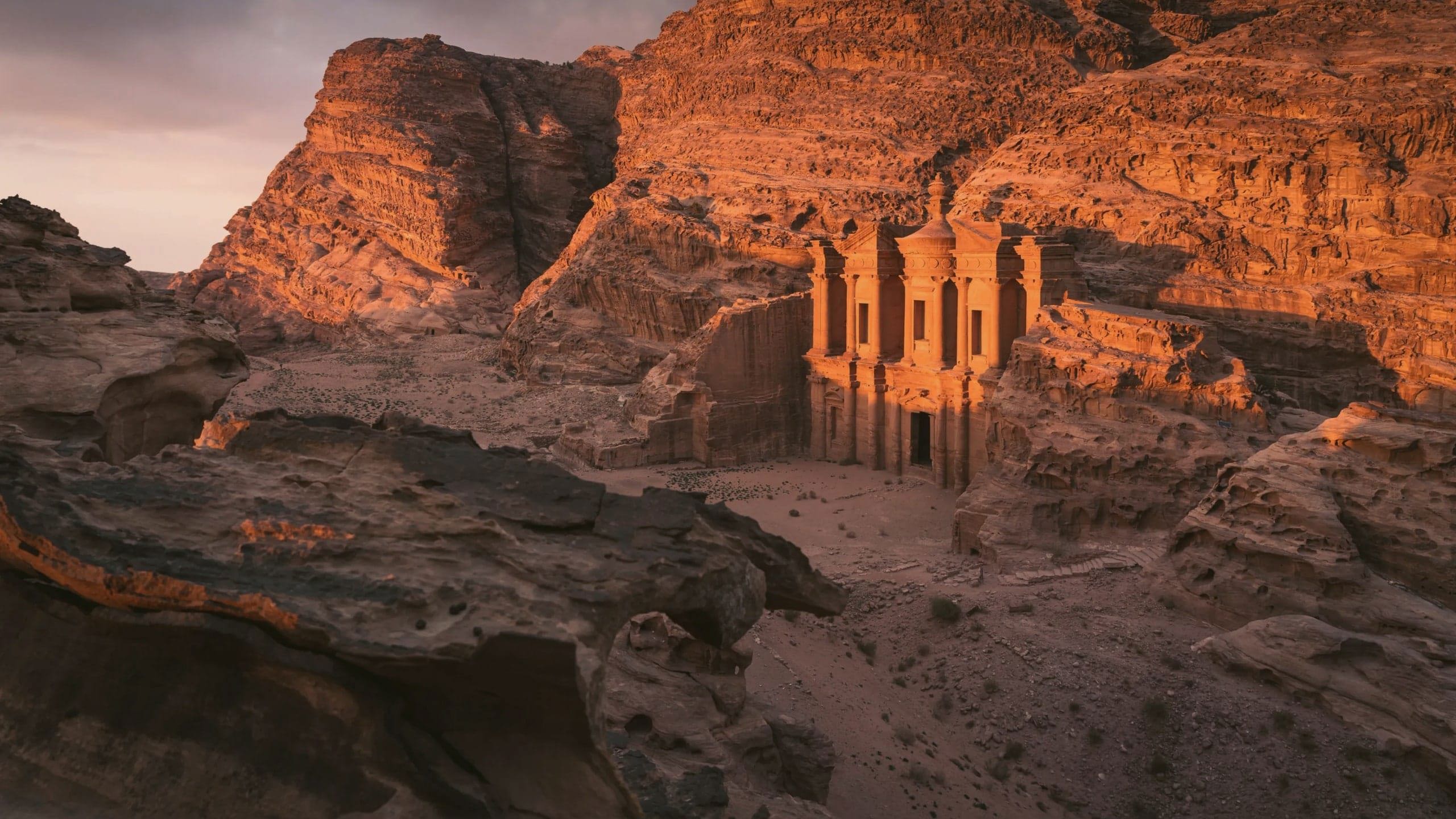 The Monastery in Petra glows at sunset, surrounded by towering sandstone cliffs on the Contiki Best of Egypt & Jordan Tour