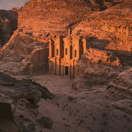 The Monastery in Petra glows at sunset, surrounded by towering sandstone cliffs on the Contiki Best of Egypt & Jordan Tour